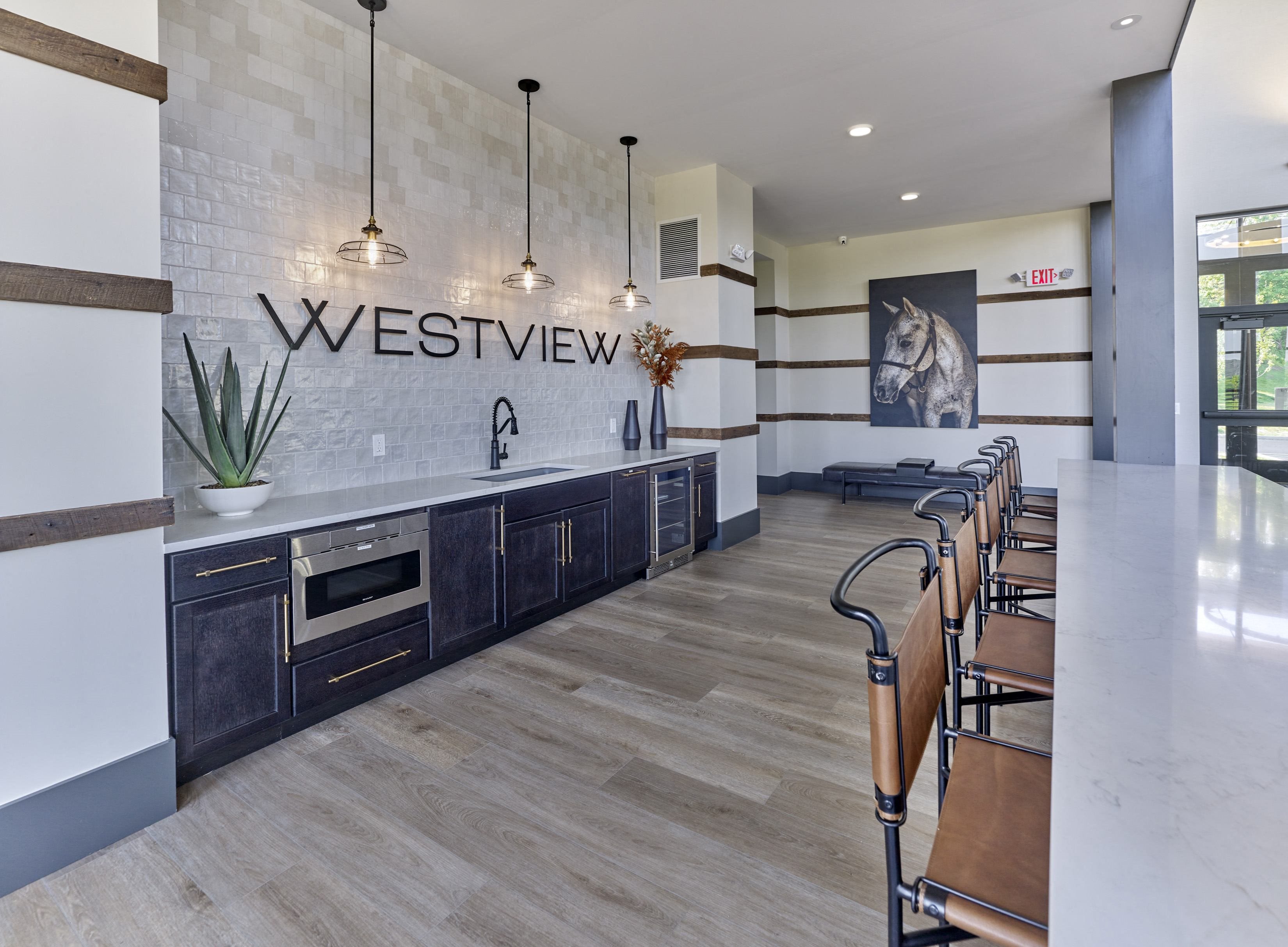 has a large kitchen with a long row of wooden chairs